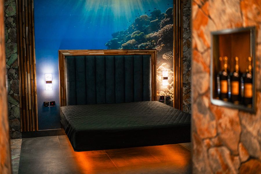 Box Océano s levitující postelí, podmořskou tapetou a kamennou stěnou